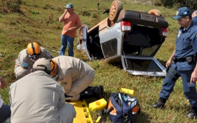 Motorista perde controle de Uno em estrada de cascalho, invade cerca e capota 