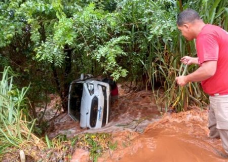 Enxurrada leva carro com motorista para dentro de córrego em Vicentina